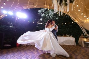 the first wedding dance of the bride and groom inside the restaurant hall in sunset light